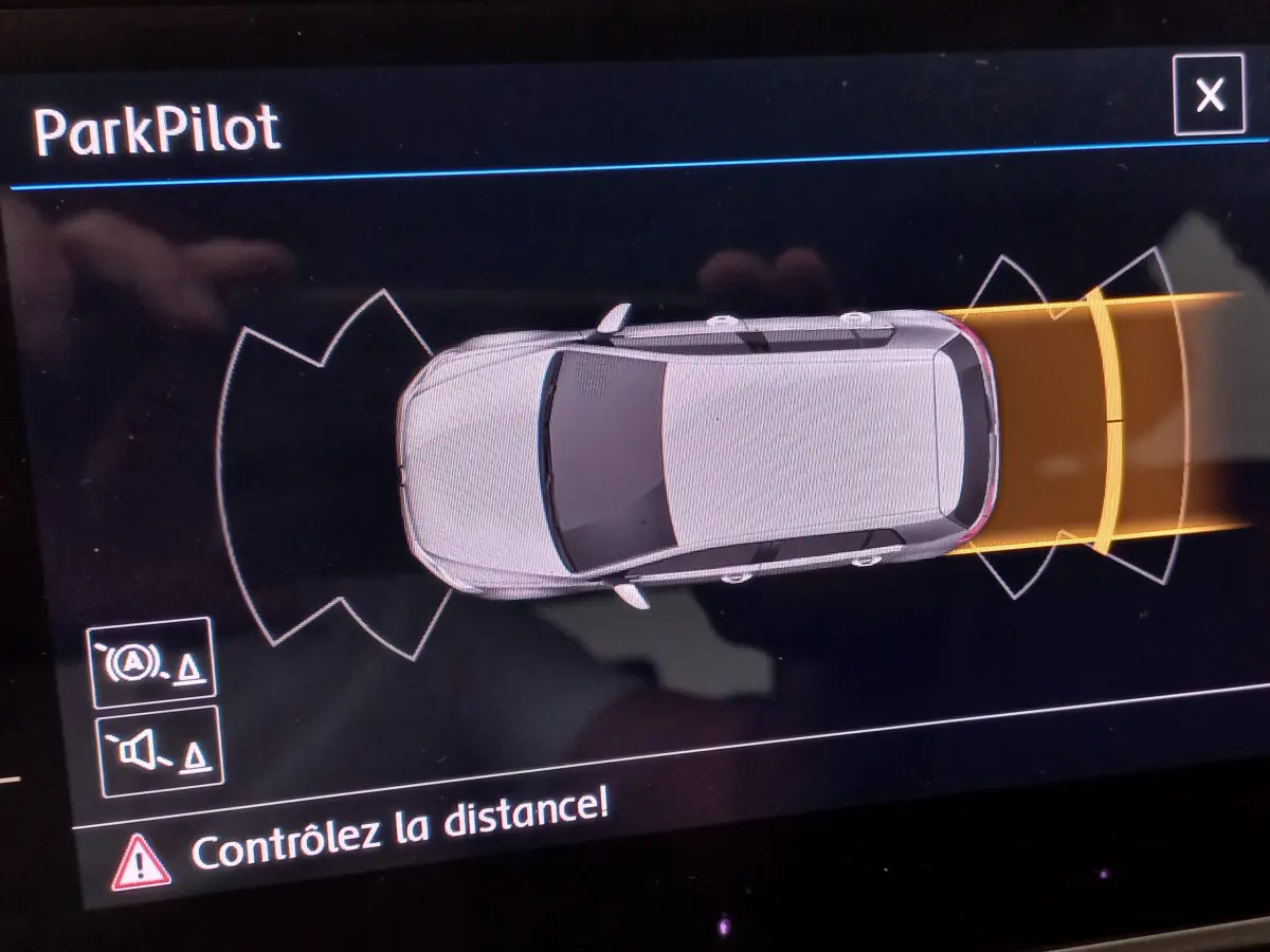 Vue en plan du système ParkPilot d'une Volkswagen Golf gris foncé, indiquant un obstacle à l'arrière avec alerte de distance.