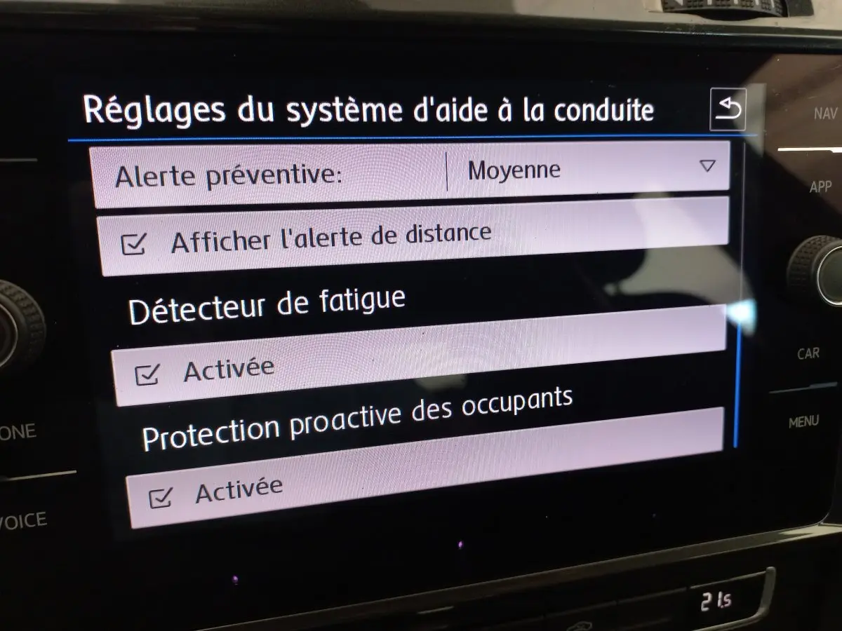 Écran tactile central affichant les réglages d'aide à la conduite dans une Volkswagen Golf gris foncé de 2019