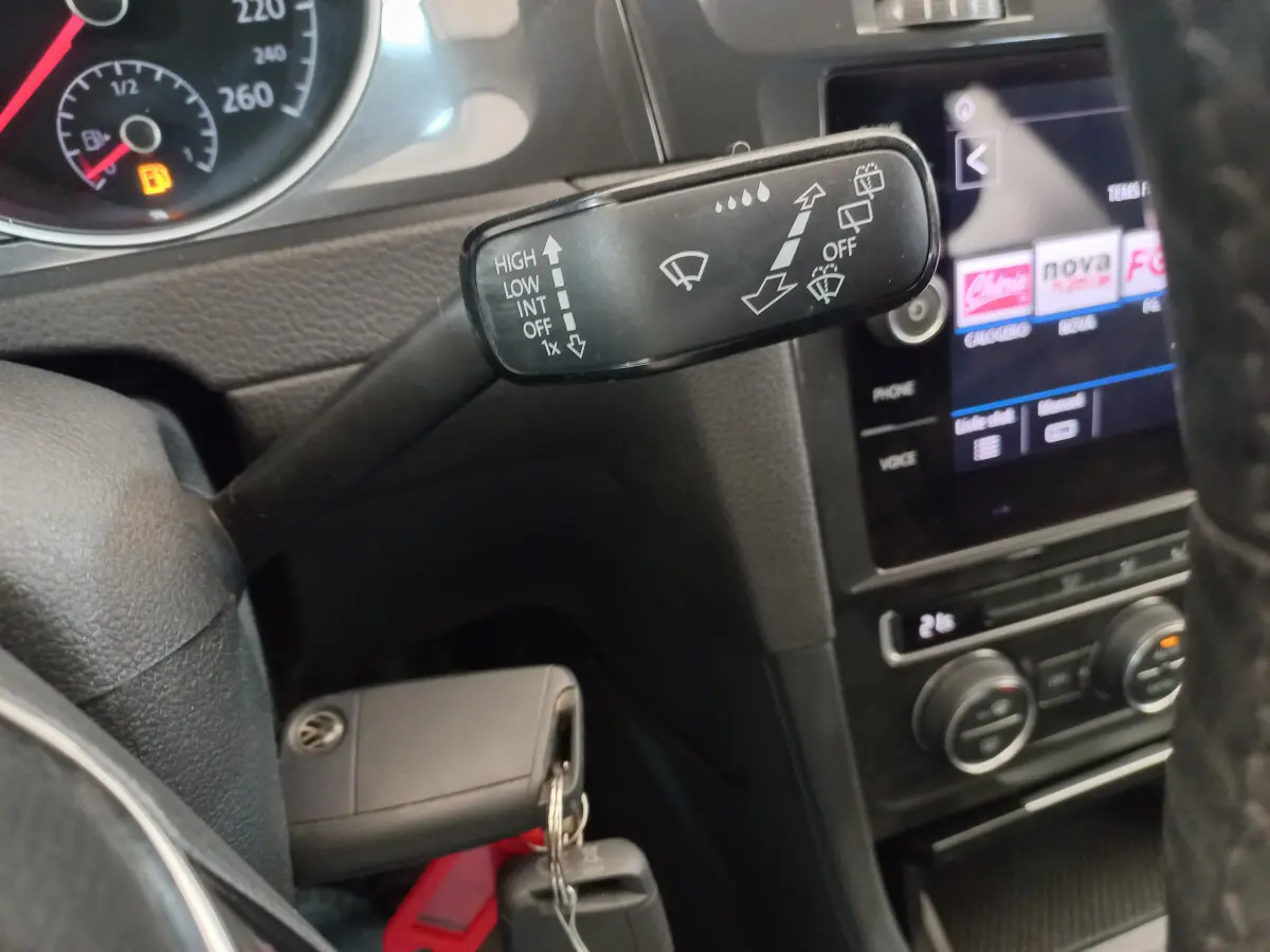 Gros plan sur la commande d’essuie-glace et le tableau de bord noir d’une Volkswagen Golf gris foncé de 2019.
