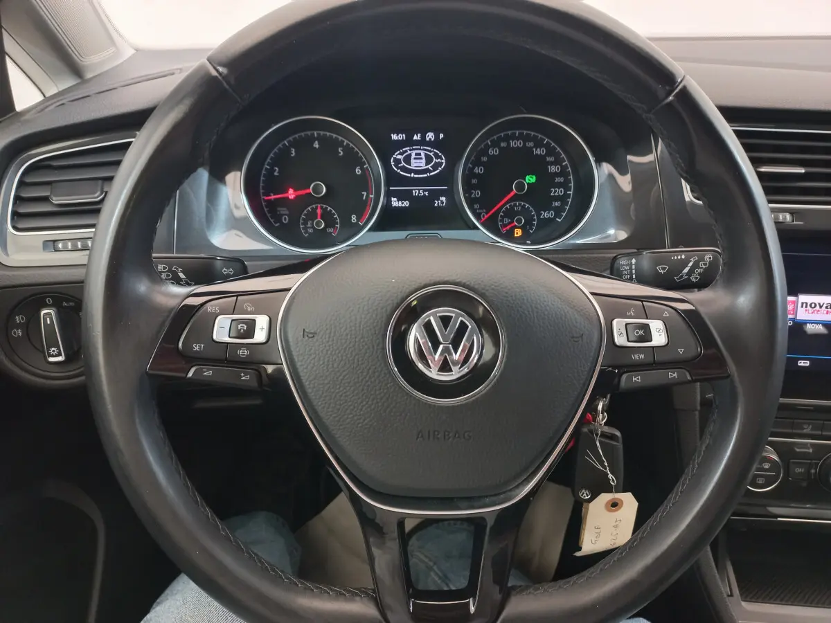 Vue rapprochée du volant cuir noir et du tableau de bord numérique d'une Volkswagen Golf gris foncé de 2019.