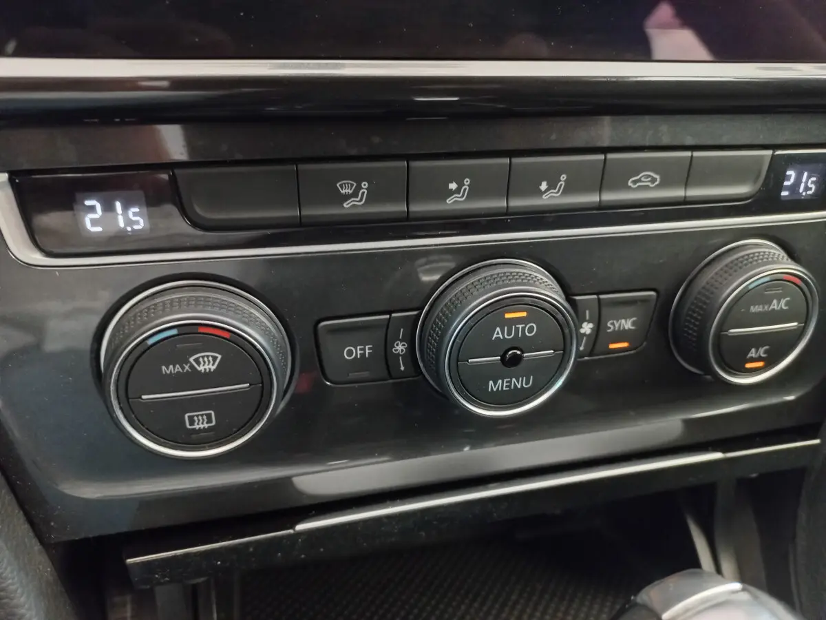 Vue rapprochée des commandes de climatisation digitale à double zone sur la Volkswagen Golf gris foncé 2019.