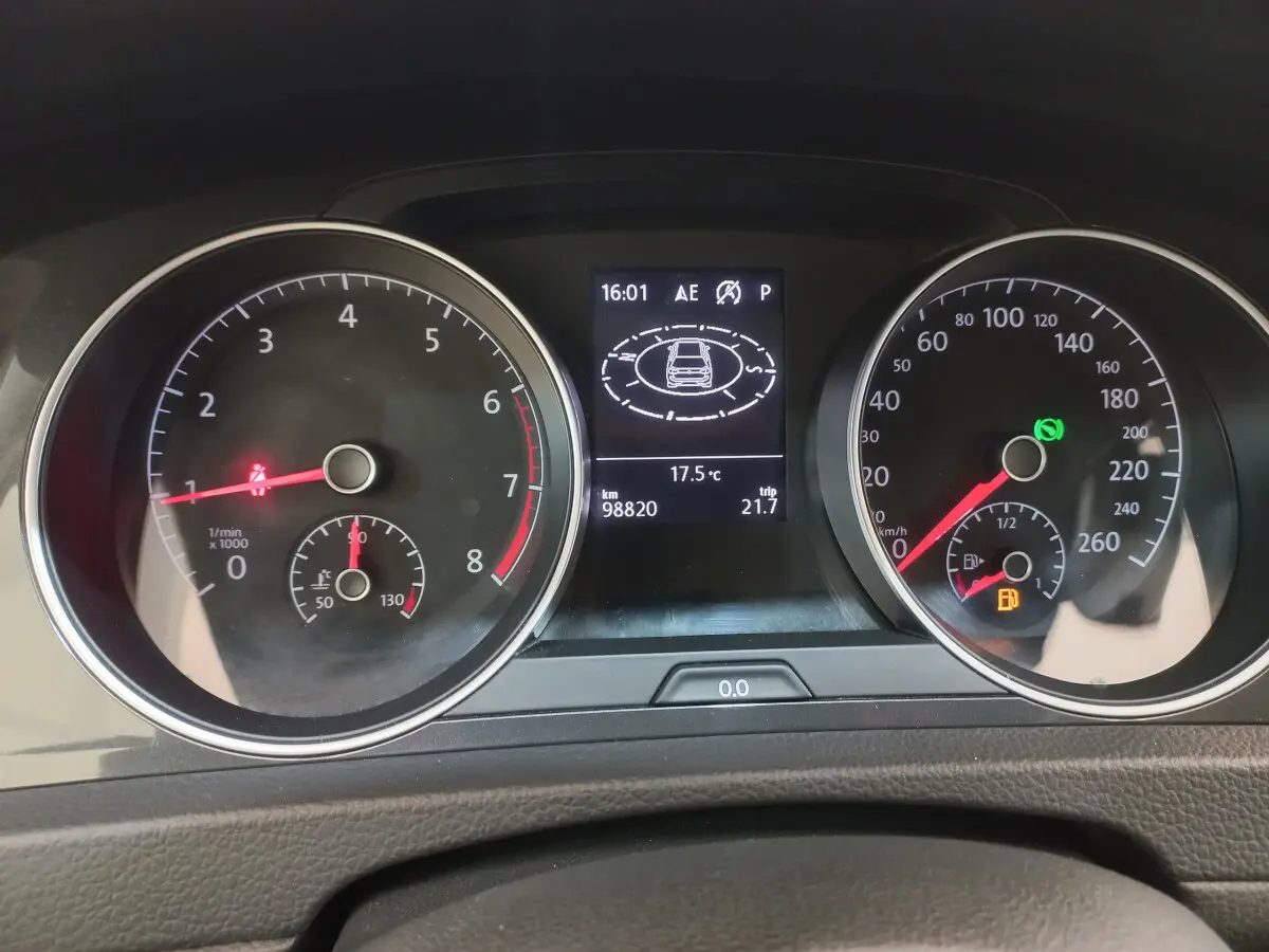 Tableau de bord de Volkswagen Golf 2019 avec compte-tours, vitesse, écran central affichant température et alertes de sécurité.