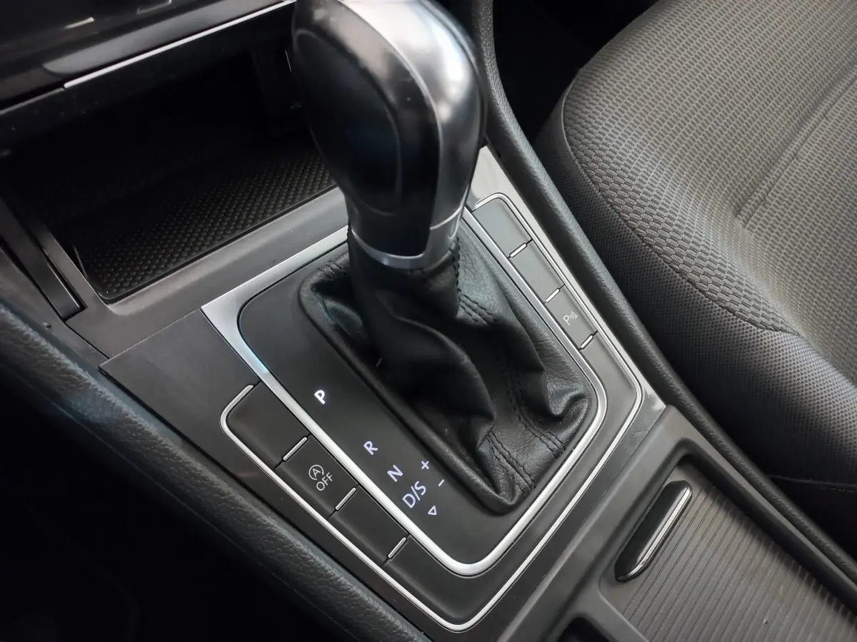 Le levier de vitesse automatique noir de la Volkswagen Golf 2019, vue rapprochée de la console centrale et siège tissu gris.