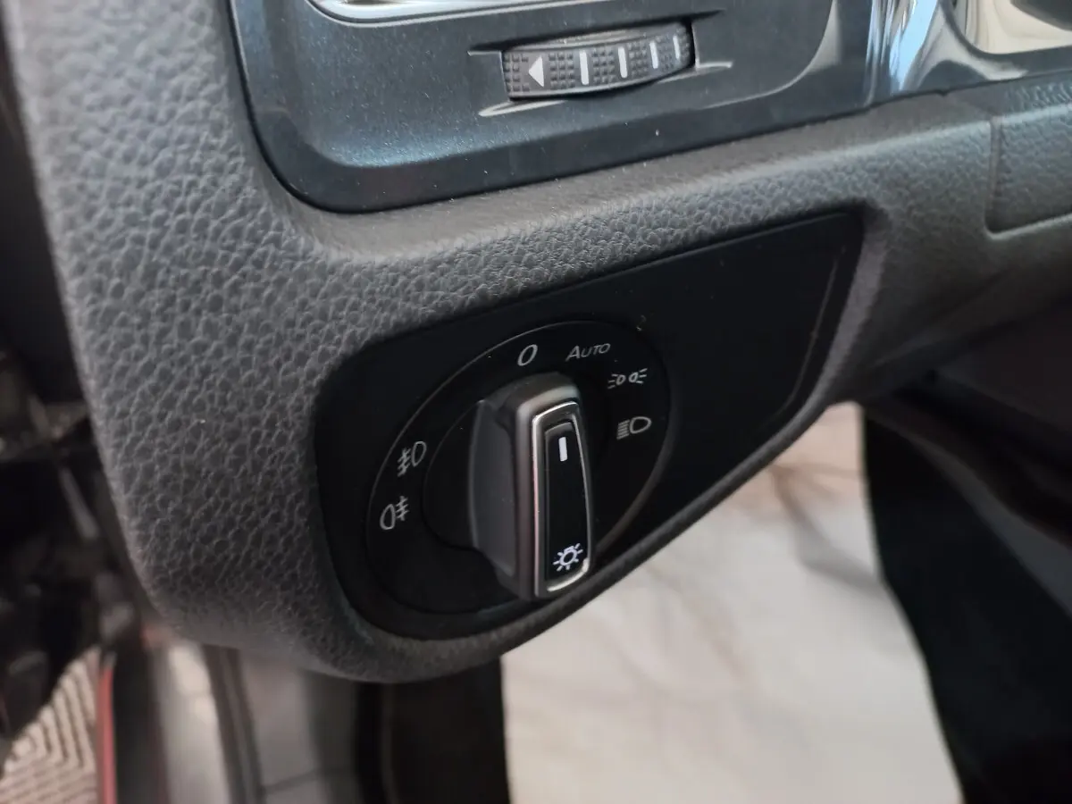 Gros plan sur le bouton de commande des phares dans l'habitacle d'une Volkswagen Golf gris foncé 2019.