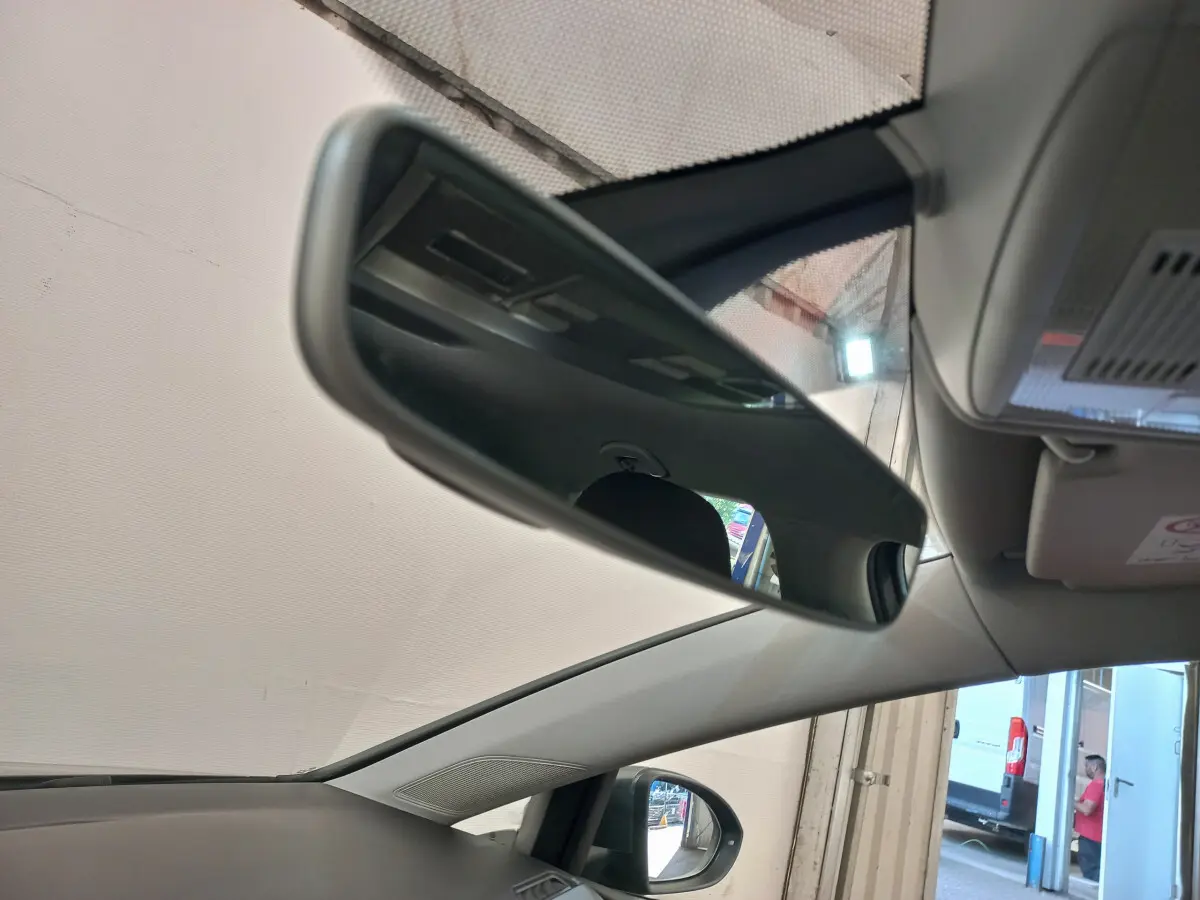Rétroviseur intérieur et partie avant du toit d'une Volkswagen Golf gris foncé vue côté gauche en intérieur.