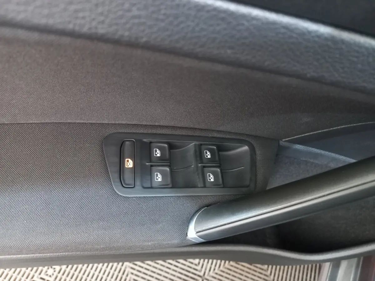 Commandes des vitres électriques sur la porte côté gauche d'une Volkswagen Golf gris foncé, finition Confort Business.