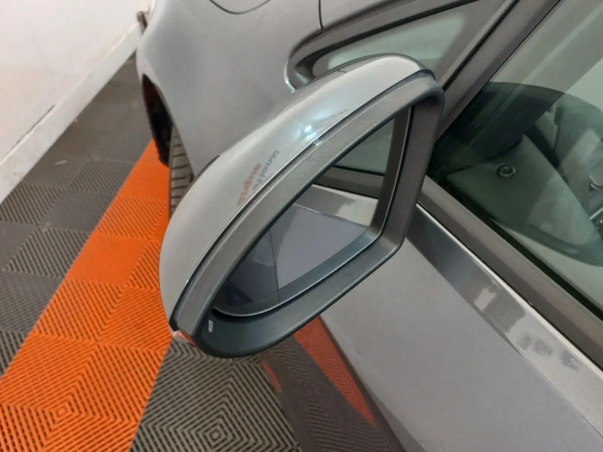 Rétroviseur côté gauche gris foncé de Volkswagen Golf 2019, vue rapprochée sur la portière et vitre avant.