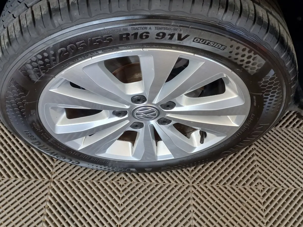 Gros plan sur la jante argentée et le pneu 205/55 R16 d'une Volkswagen Golf gris foncé de 2019.