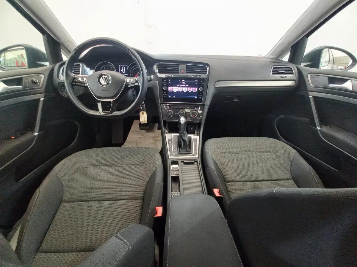 Vue intérieure avant de la Volkswagen Golf 1.0 TSI 115 DSG7 avec tableau de bord noir et volant cuir multifonctions.