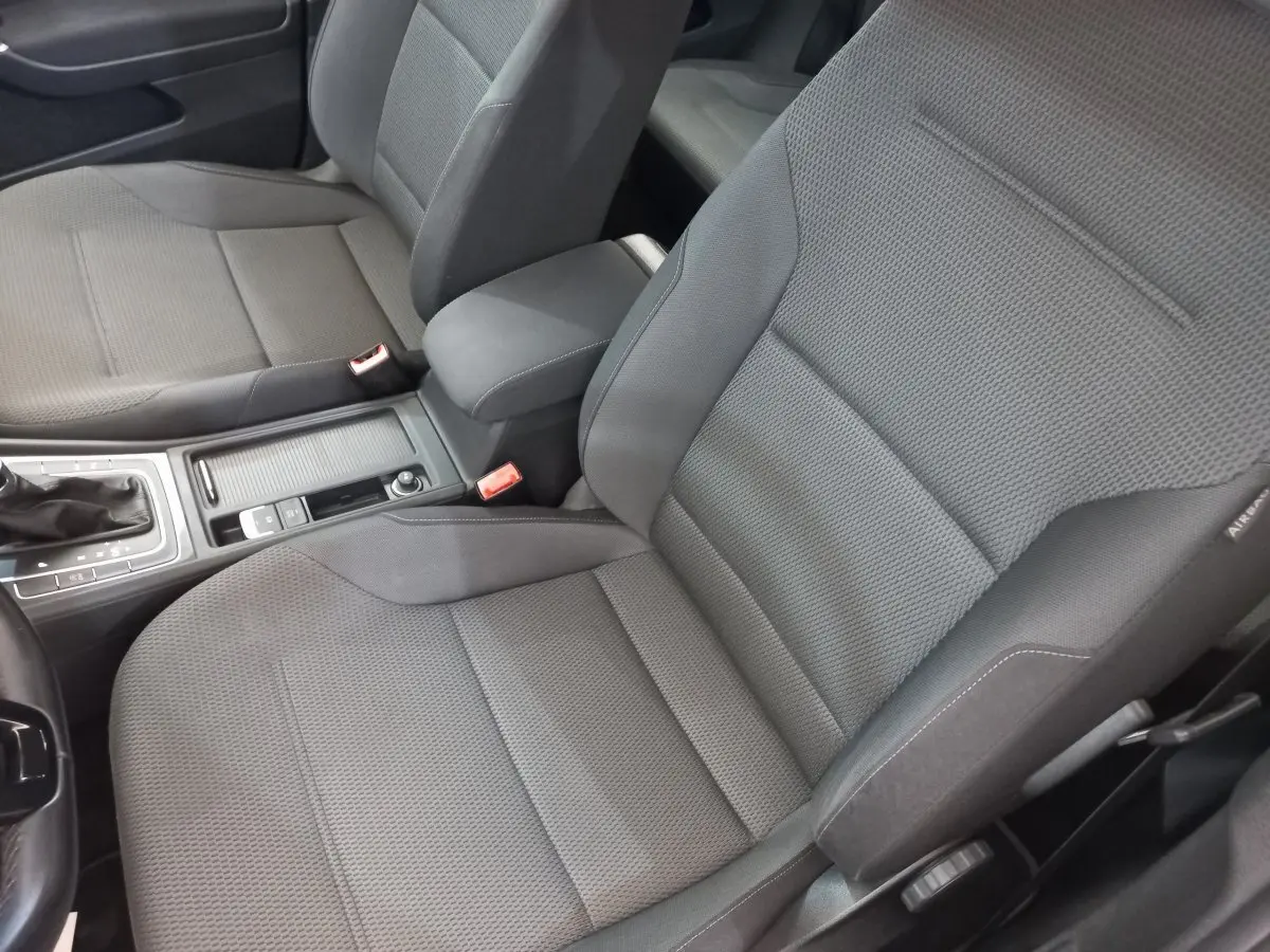 Gros plan sur les sièges avant gris tissu et la console centrale d'une Volkswagen Golf 2019 côté conducteur.