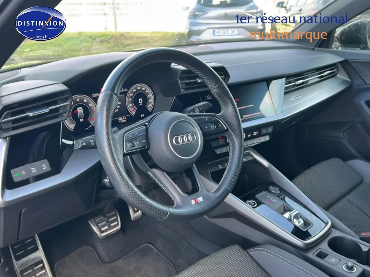 Intérieur noir de l'Audi A3 Sportback 2024 vu côté conducteur, volant cuir multifonction et tableau de bord digital.