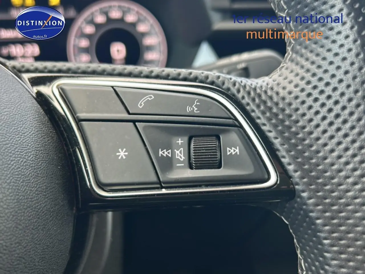 Gros plan sur les commandes audio au volant cuir perforé de l'Audi A3 Sportback noir 2024.