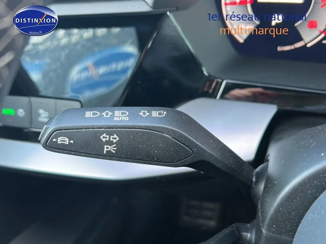 Gros plan sur la manette de clignotants à gauche du volant dans l'habitacle d'une Audi A3 Sportback noire 2024