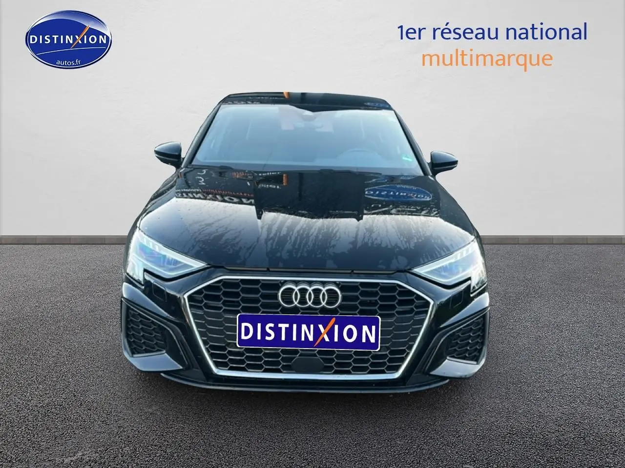 Audi A3 Sportback noir vue de face, mettant en valeur la calandre hexagonale et les phares LED distinctifs.