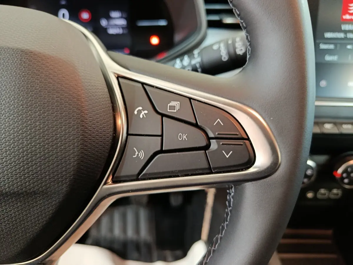 Gros plan sur les commandes du volant côté droit d'une Renault Clio Evolution Blue dCi 100 2025, intérieur noir.