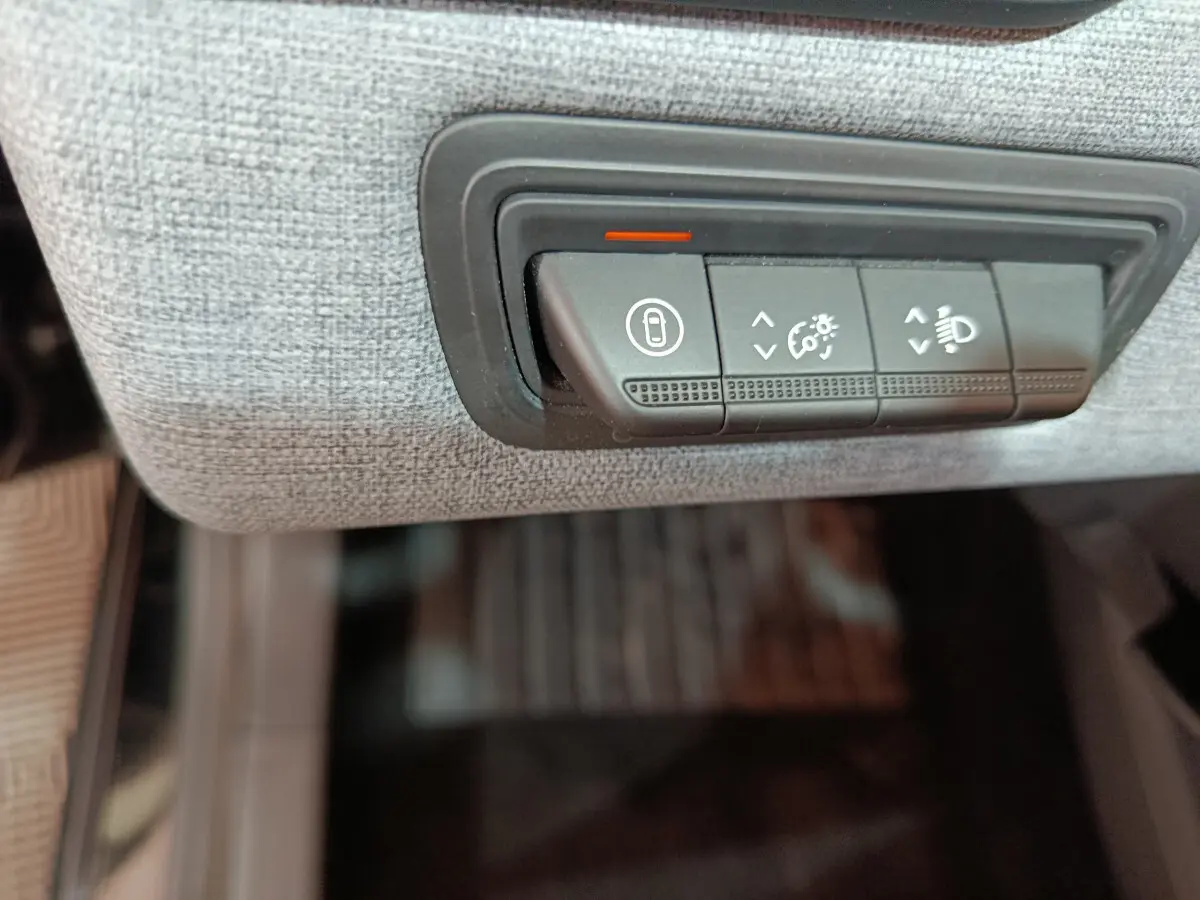 Boutons de réglage d'éclairage et verrouillage sur tableau de bord gris clair d'une Renault Clio Evolution Blue dCi 2025.