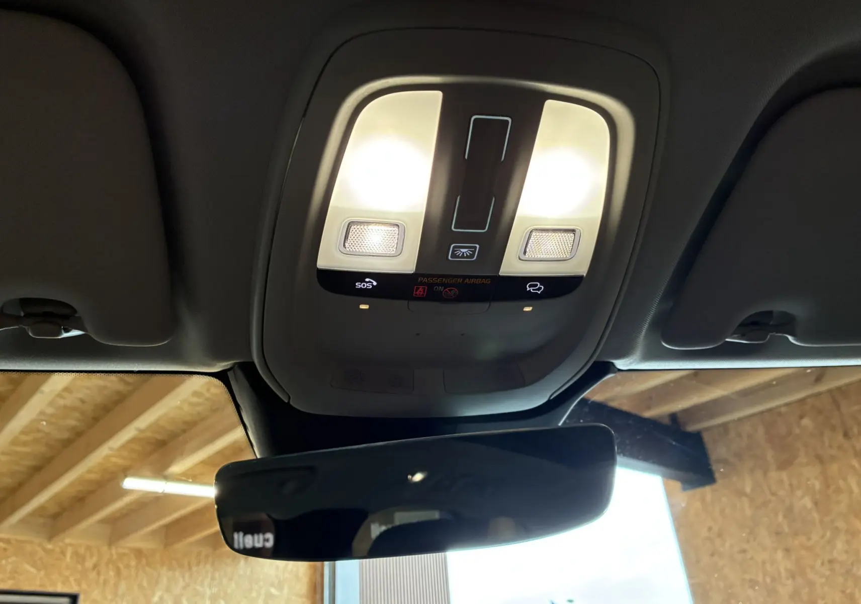 Vue intérieure du plafonnier avec éclairage et commandes SOS du Volvo XC60 bleu 2023.