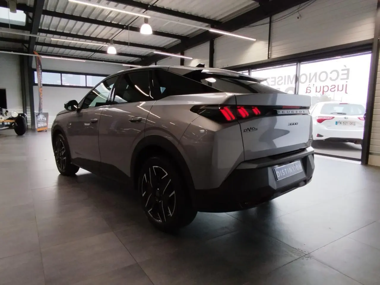 Vue 3/4 arrière gauche du Peugeot 3008 gris Artense avec feux arrière LED 3 griffes et jantes alliage 19 pouces.