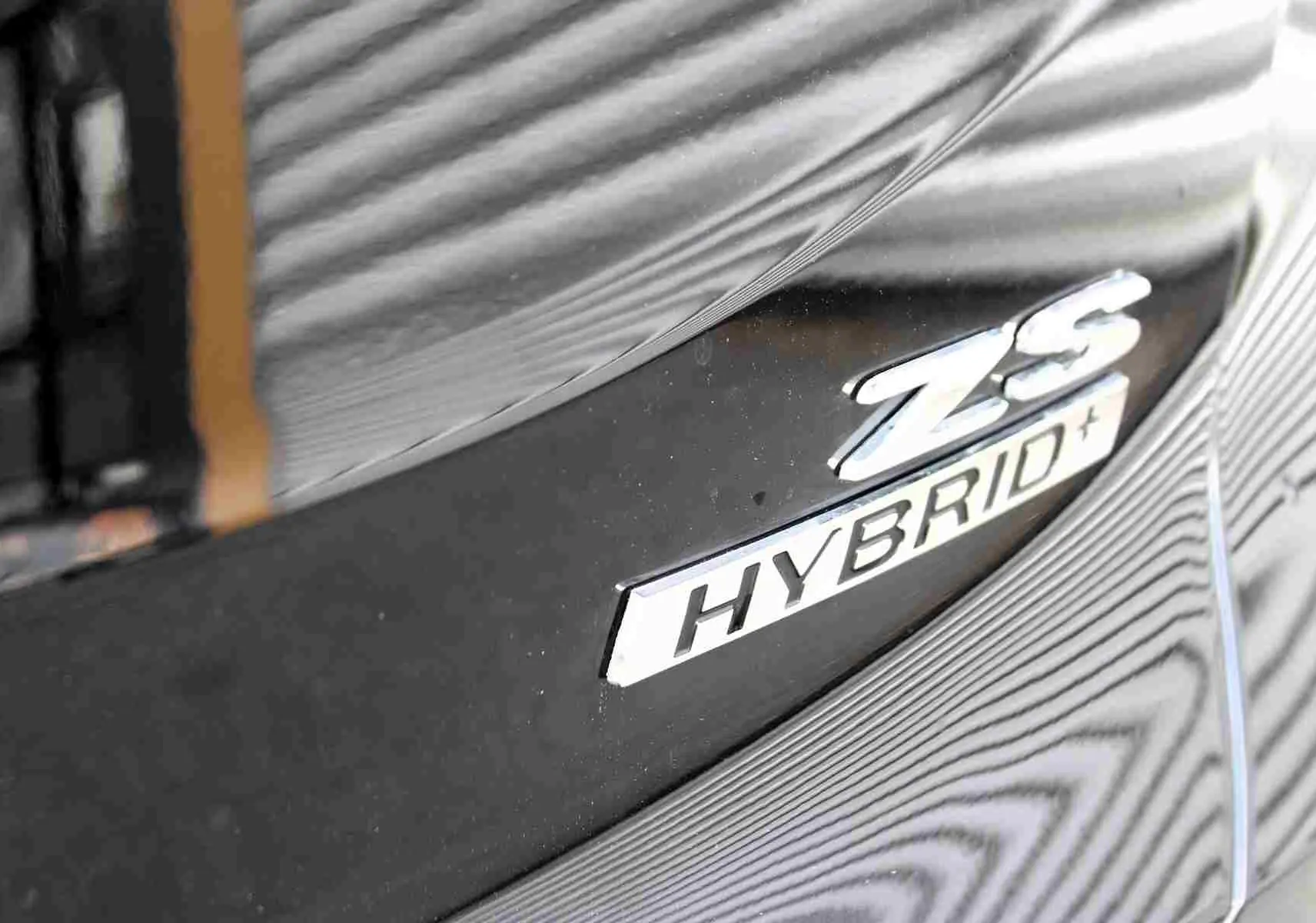 Gros plan sur la roue avant gauche noire brillante du MG ZS 1.5L Hybrid+ Pebble Black Metal.