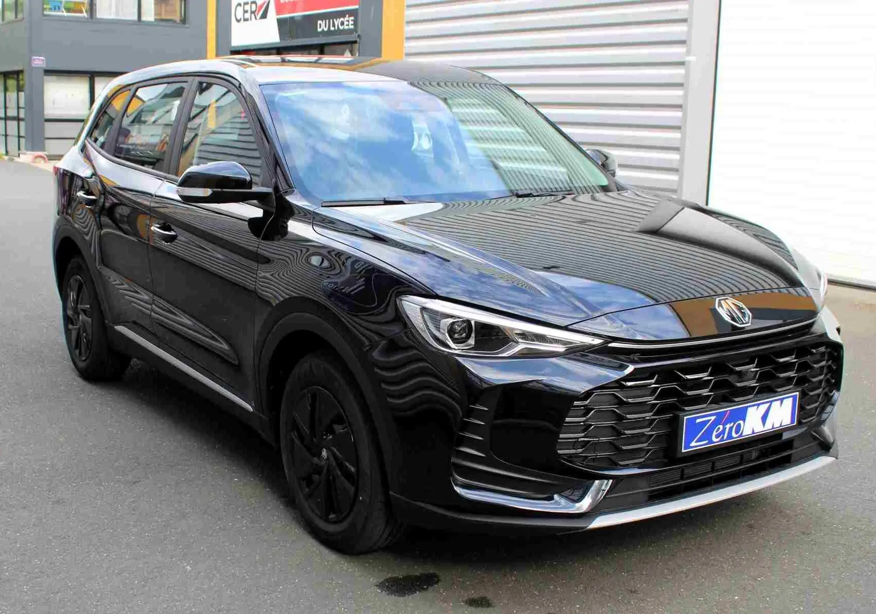 Vue intérieure centrée sur le volant et tableau de bord du MG ZS 1.5L Hybrid+ noir avec écran tactile et commandes au volant.