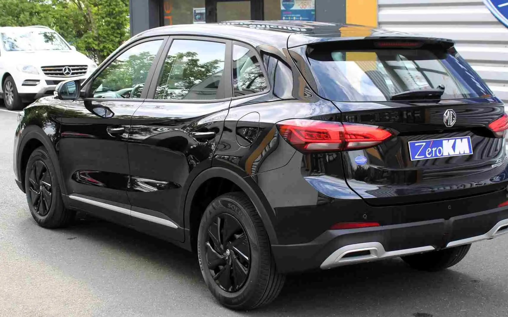 Vue intérieure côté arrière droit du siège tissu gris du MG ZS 1.5L HYBRID+ Pebble Black Metal avec ceinture de sécurité.