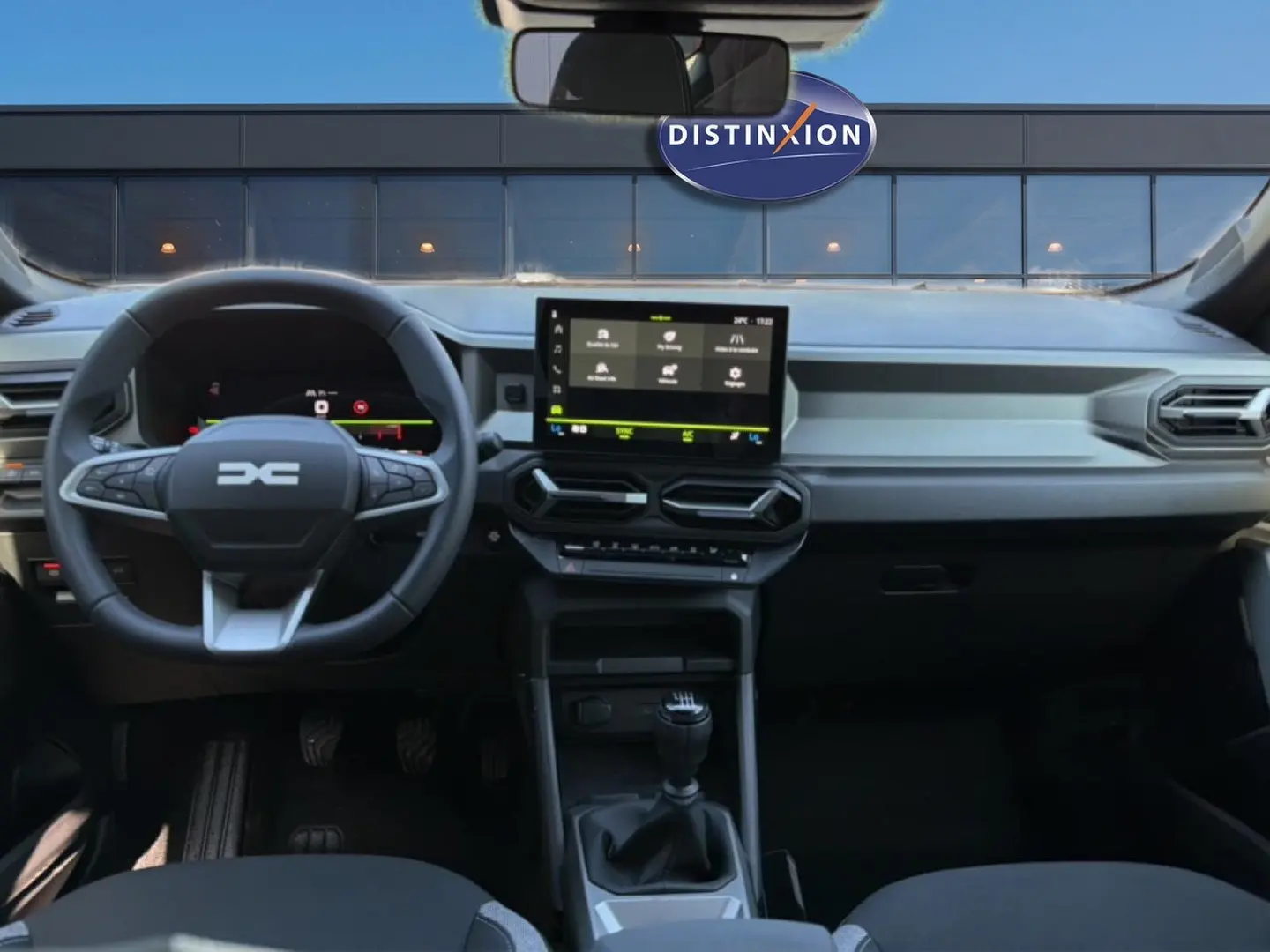 Vue intérieure avant du tableau de bord et volant multifonction du Dacia Bigster blanc, avec écran tactile et boîte manuelle.