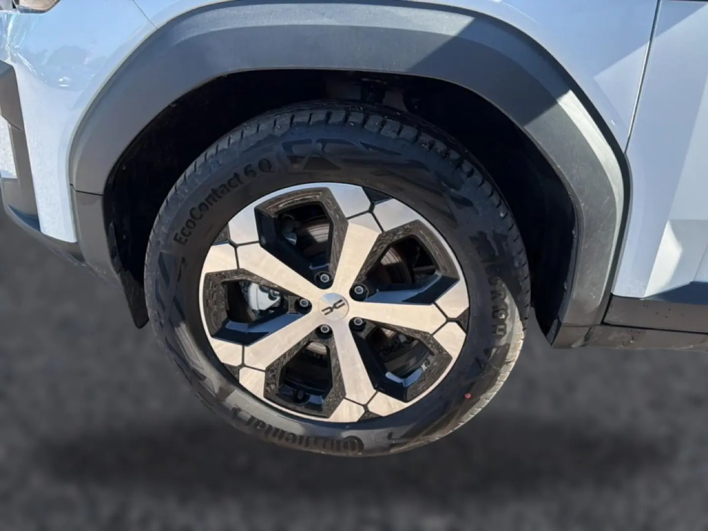 Gros plan sur la roue avant droite du Dacia Bigster blanc, mettant en valeur la jante alu au design géométrique.