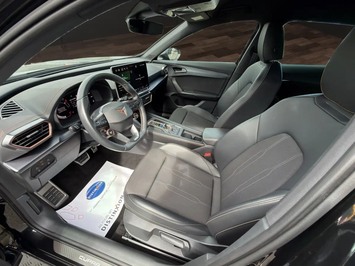 Vue intérieure côté conducteur du CUPRA Formentor 2025 avec sièges noirs et tableau de bord moderne à écran tactile.