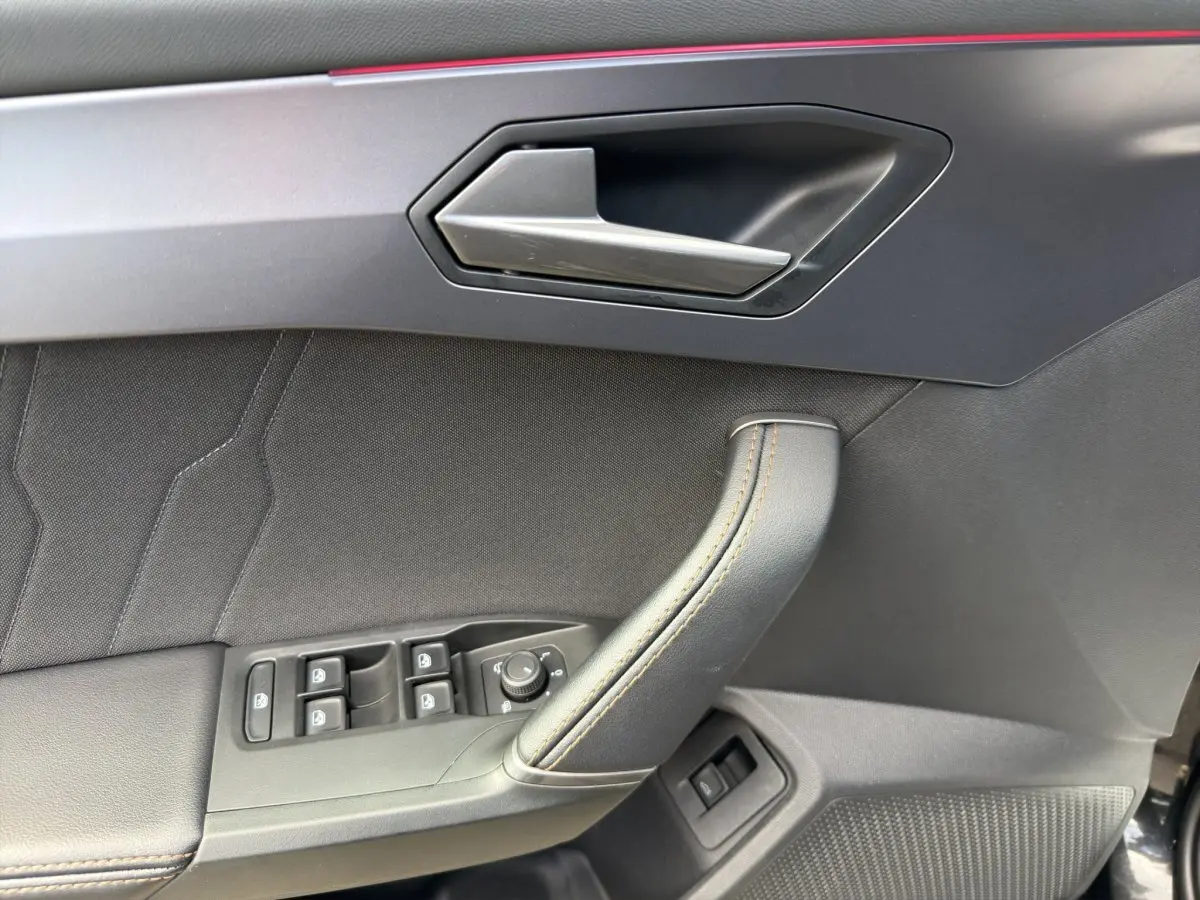 Vue rapprochée de la porte avant gauche de la CUPRA Formentor 2025 avec garniture noire et surpiqûres contrastantes.