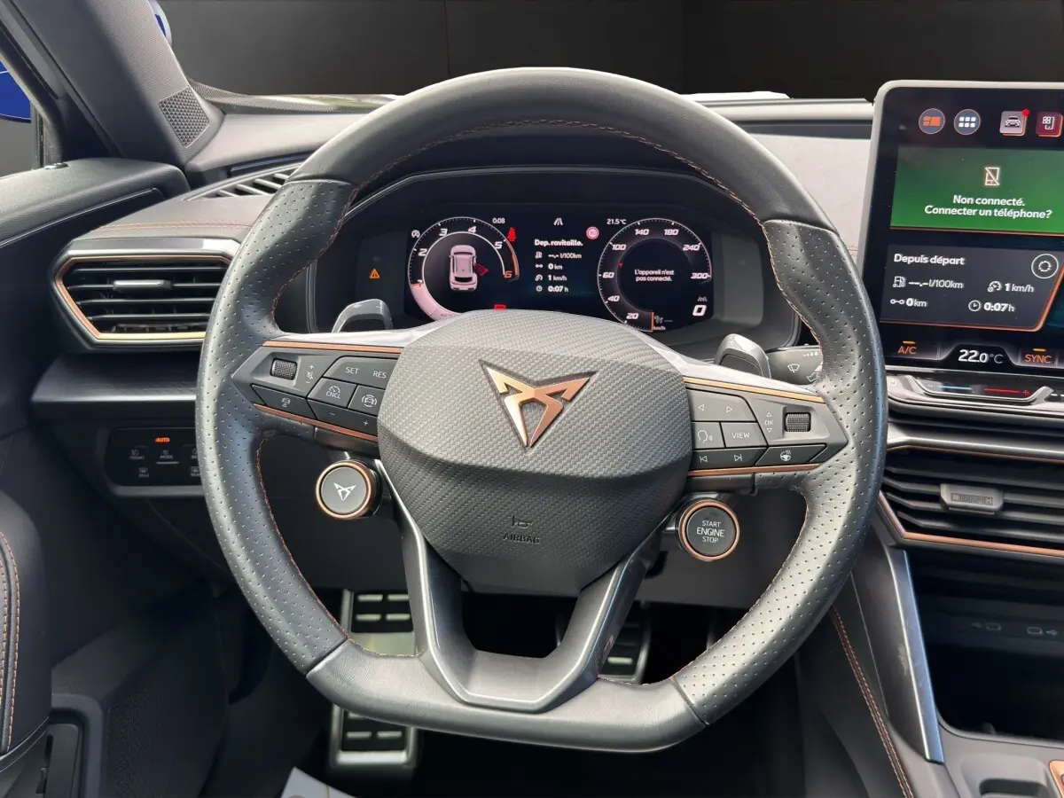 Vue rapprochée du volant en cuir perforé noir avec logo CUPRA cuivré et tableau de bord numérique du Formentor 2025.