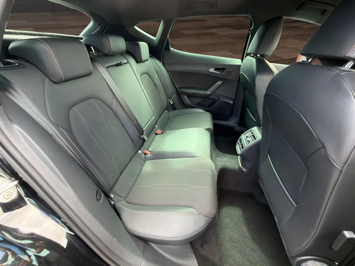 Vue intérieure arrière du CUPRA Formentor 2025 montrant les sièges noirs en cuir et tissu avec surpiqûres contrastantes.
