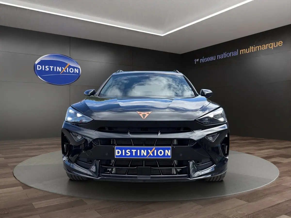 Vue avant d'un CUPRA Formentor noir brillant avec logo cuivré, dans un showroom au sol en parquet.