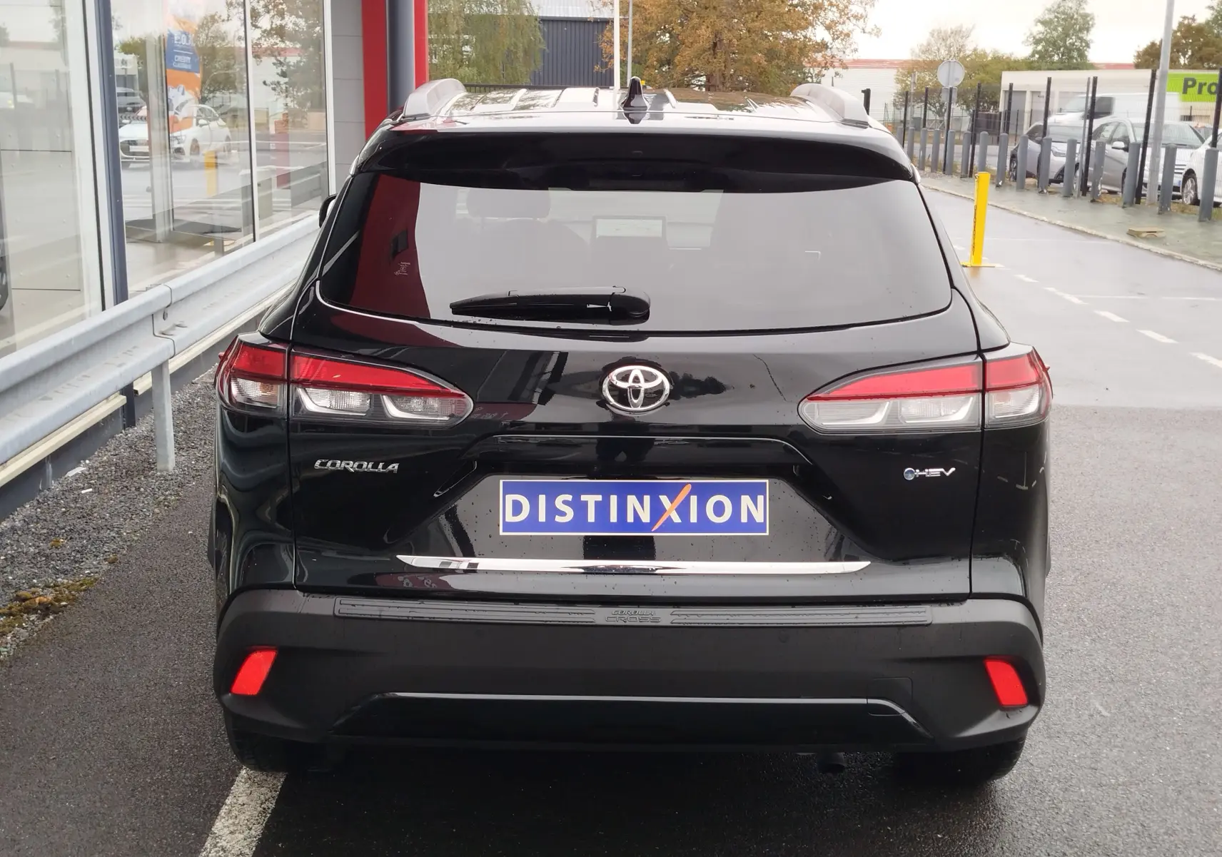 Vue arrière d'un Toyota Corolla Cross Hybrid 140 Luxury Limited noir Attitude, avec feux LED et logo hybride visible.