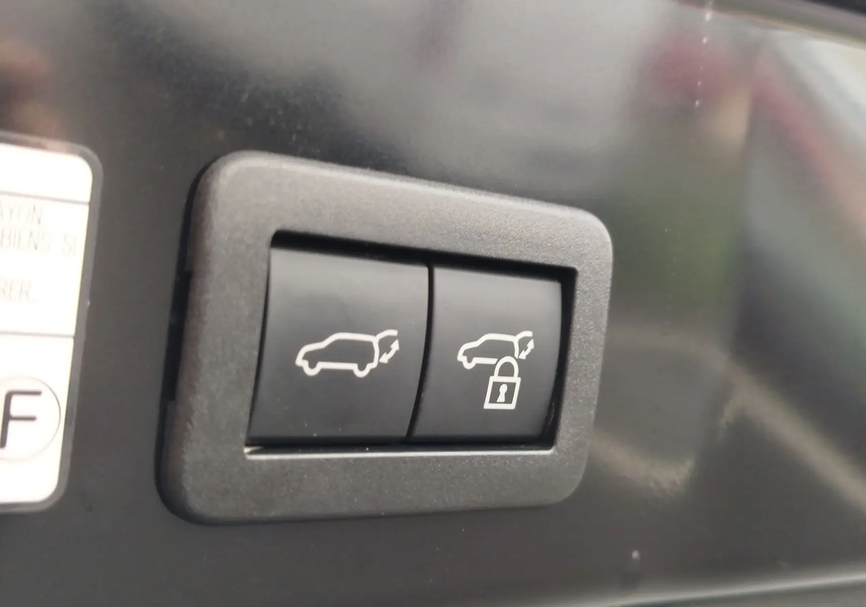 Boutons de commande du hayon avec fonction ouverture et verrouillage sur Toyota Corolla Cross noir.
