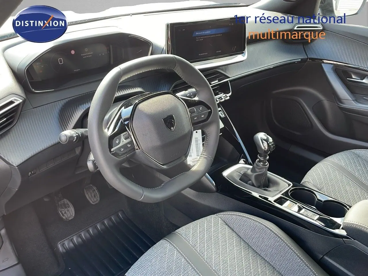 Intérieur du Peugeot 2008 2025 en gris, vue côté conducteur montrant volant compact et levier de vitesse manuel.