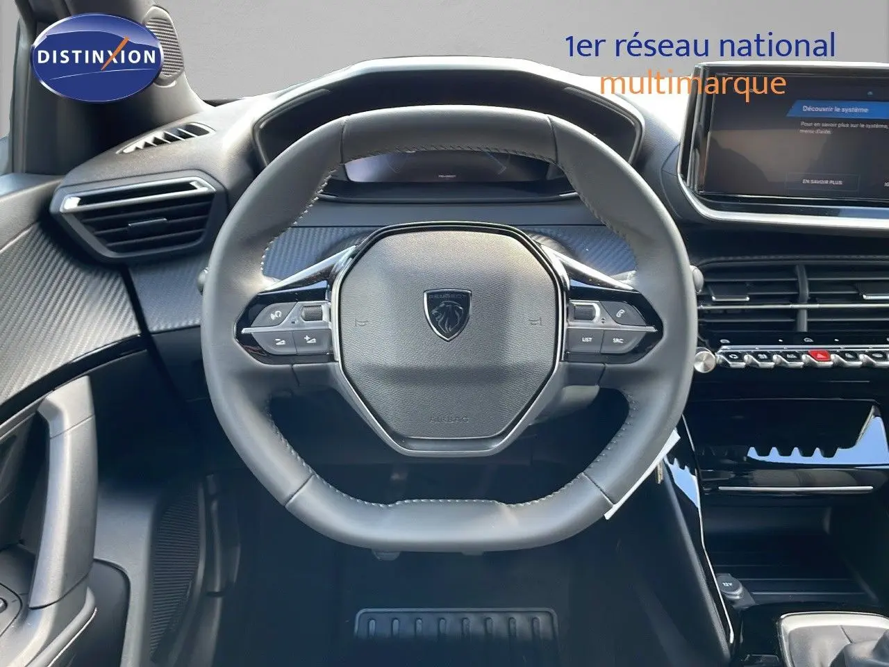 Vue frontale du volant cuir noir et du tableau de bord moderne de la Peugeot 2008 gris Artense 2025.