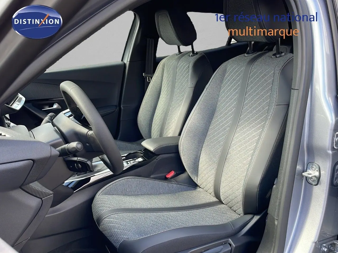 Vue intérieure côté conducteur du PEUGEOT 2008 gris Artense, sièges tissu et cuir noir avec console centrale moderne.