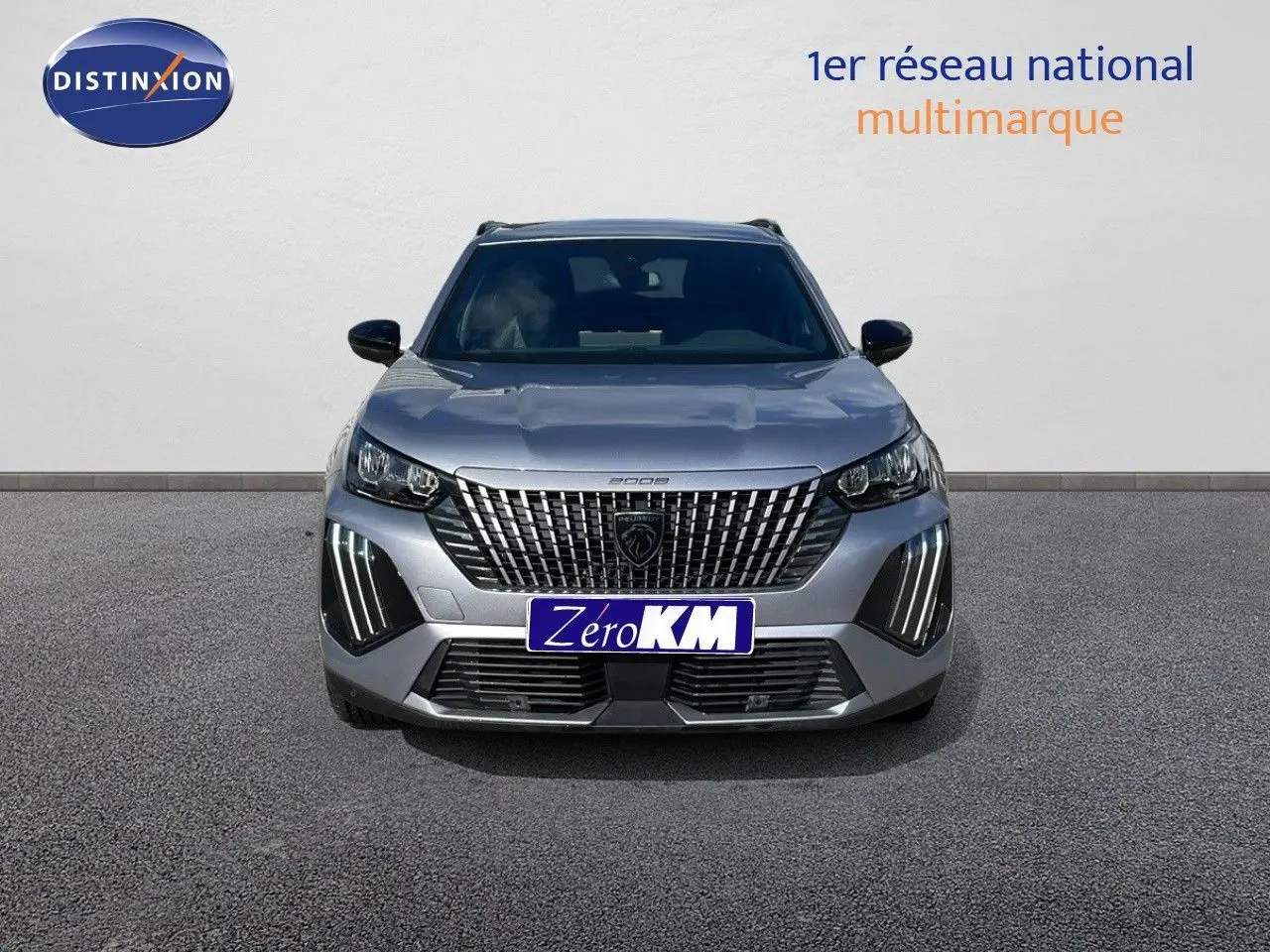 Vue frontale d'un Peugeot 2008 gris Artense métal avec calandre imposante et feux LED verticaux allumés.