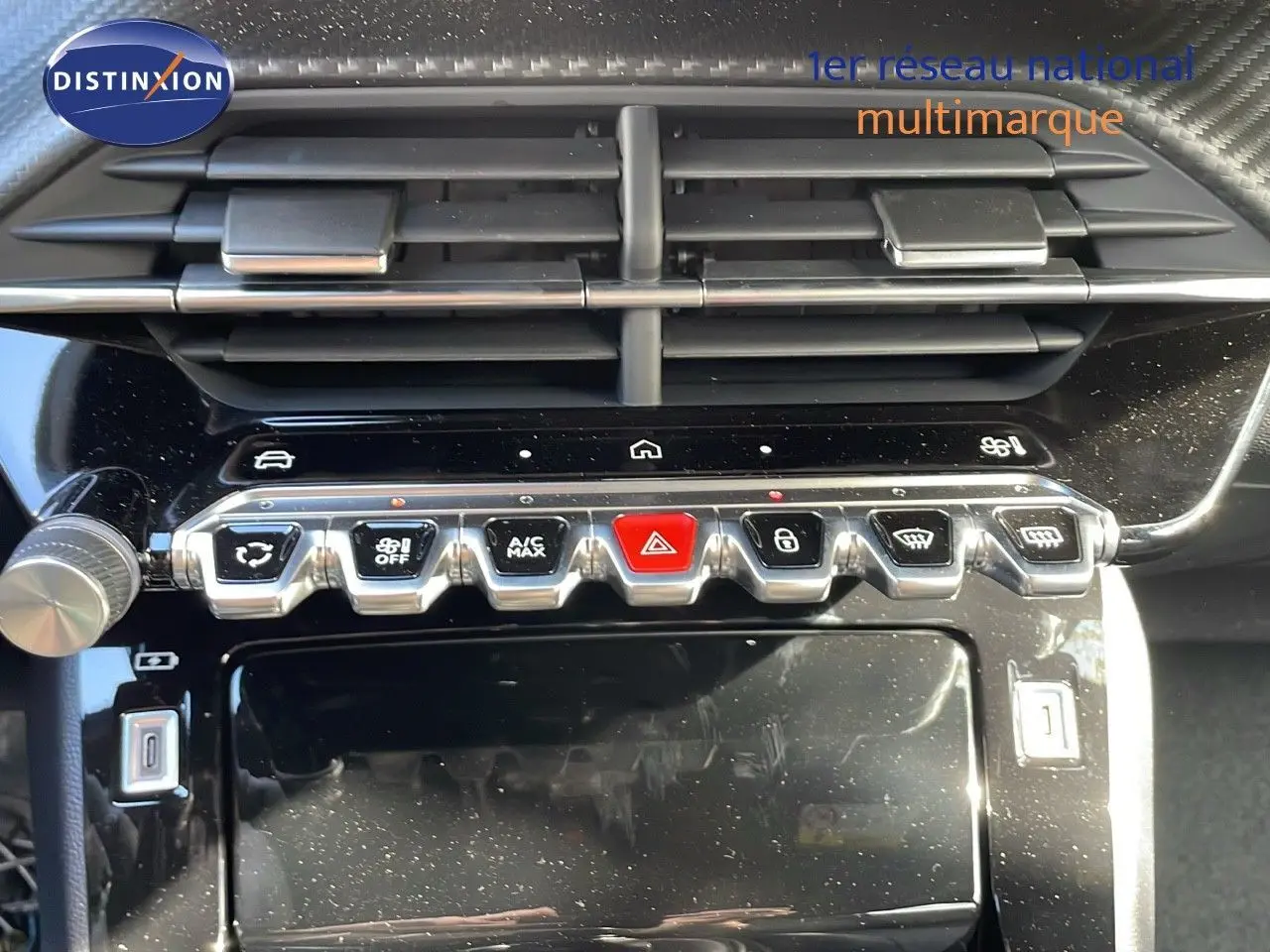 Vue rapprochée de la console centrale du Peugeot 2008 gris Artense, montrant les commandes climatisation et boutons fonctionnels.