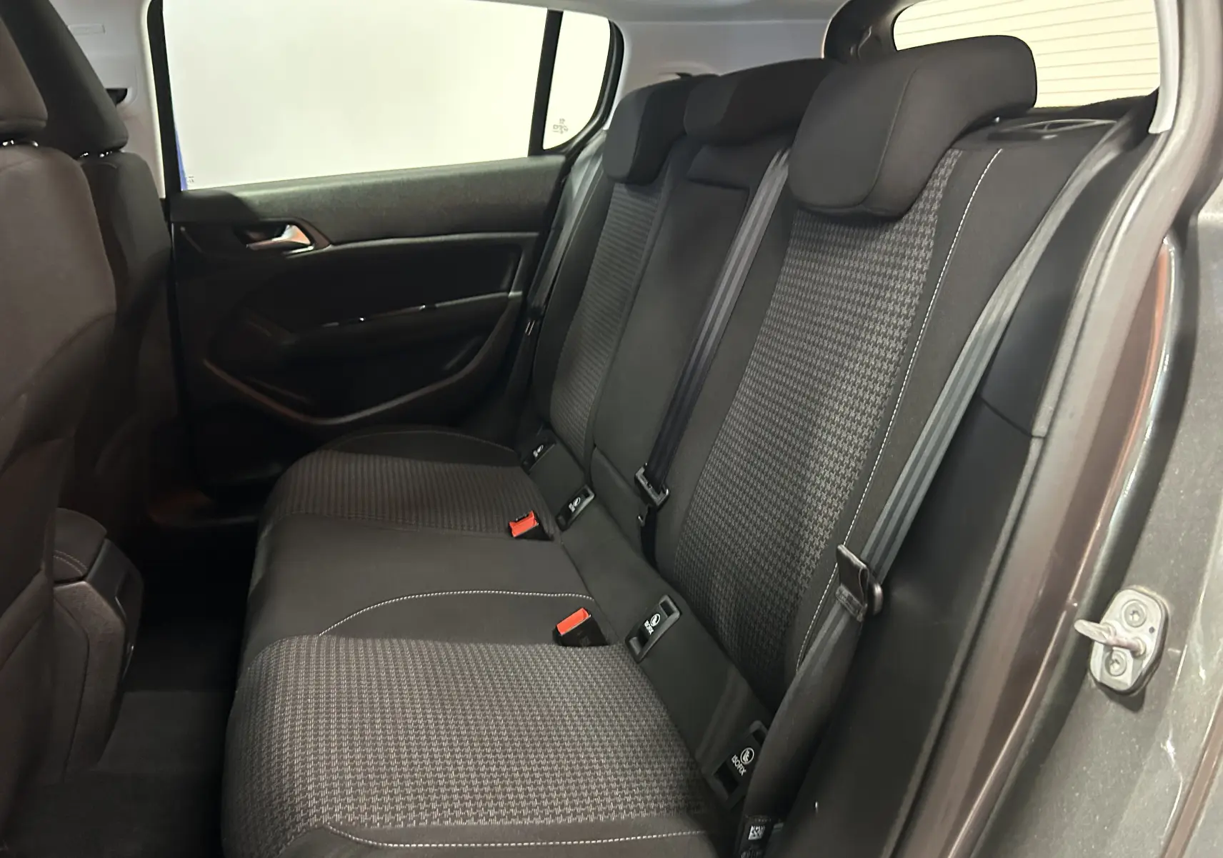 Vue intérieure côté droit des sièges arrière en tissu gris foncé de la Peugeot 308 Active Pack 2021, porte ouverte.
