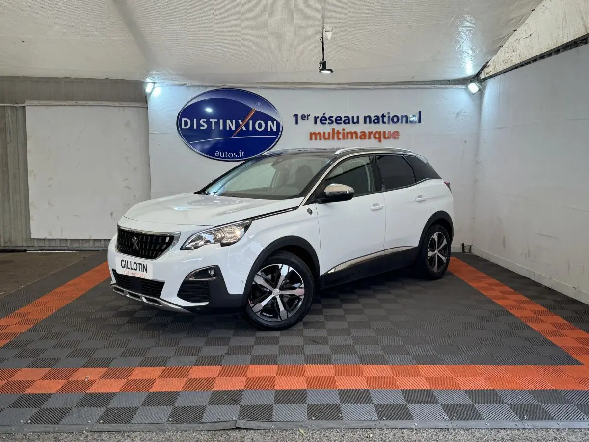 Peugeot 3008 blanc vue 3/4 avant droit, avec jantes noires et toit noir dans un showroom multimarque.
