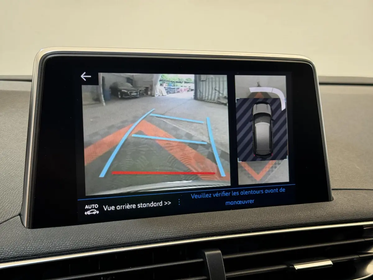 Écran tactile intérieur du Peugeot 3008 blanc montrant la caméra de recul avec guidage et vue 360° en stationnement.