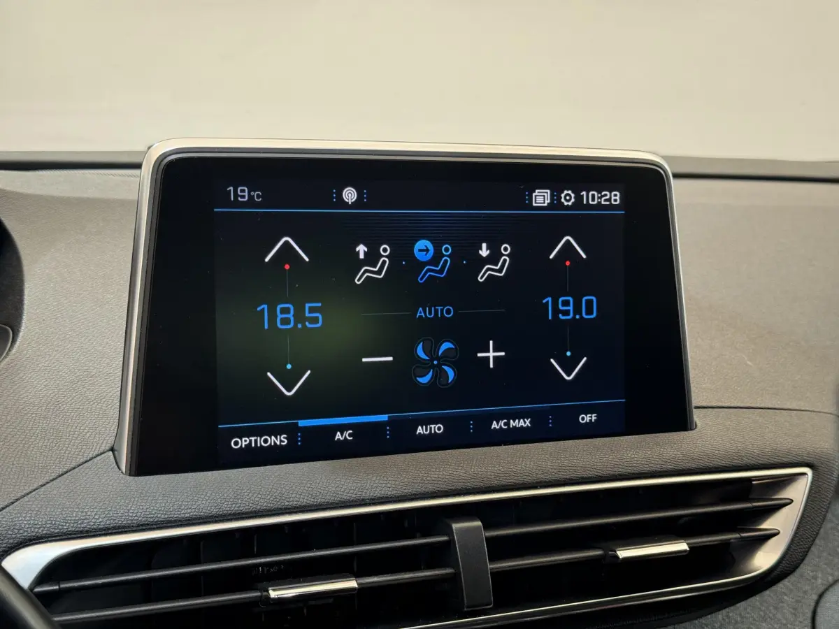 Écran tactile central affichant la climatisation bi-zone dans l'habitacle d'un Peugeot 3008 blanc, vue rapprochée.