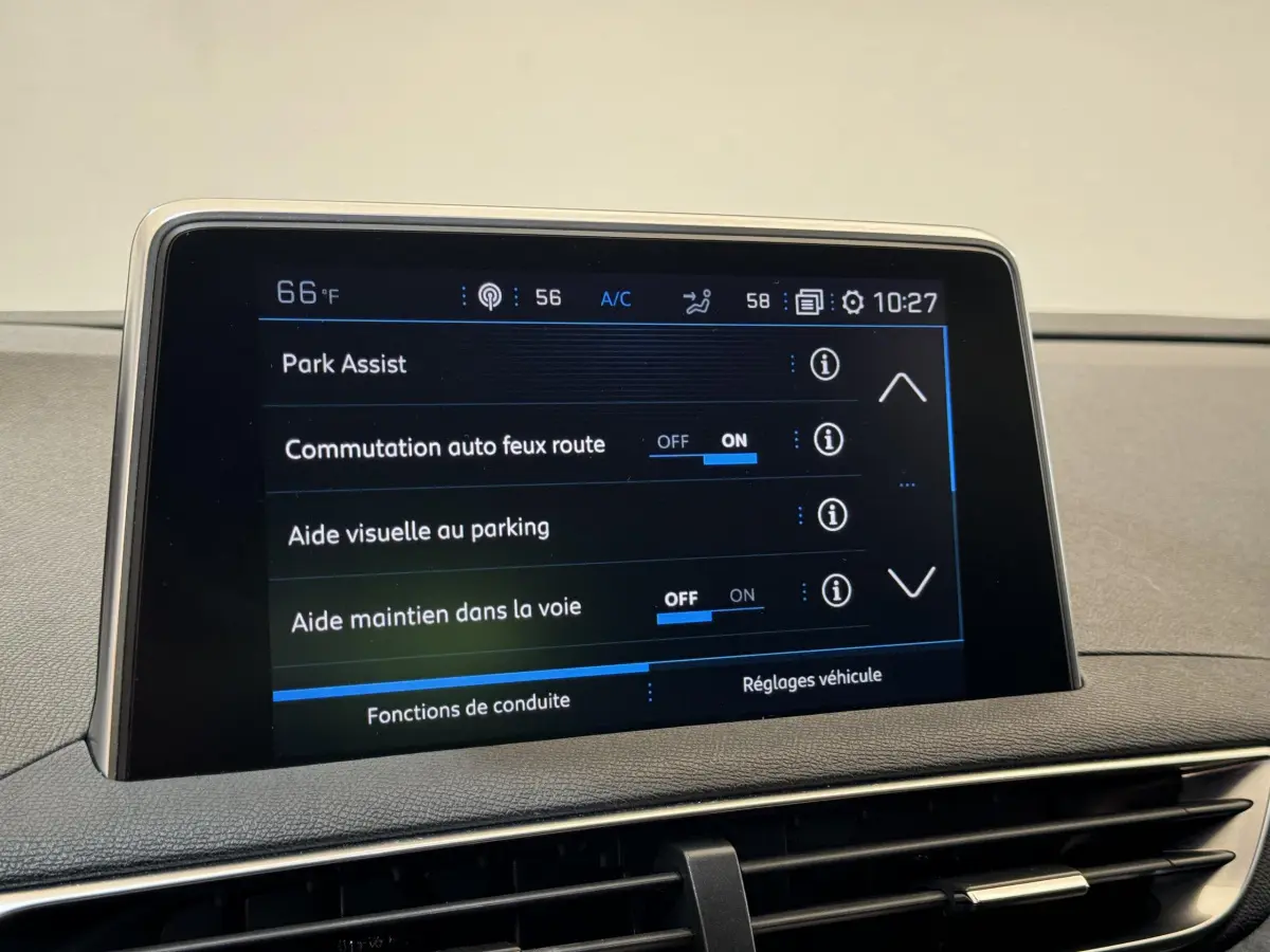 Écran tactile central du tableau de bord du Peugeot 3008 blanc affichant les aides à la conduite et park assist.