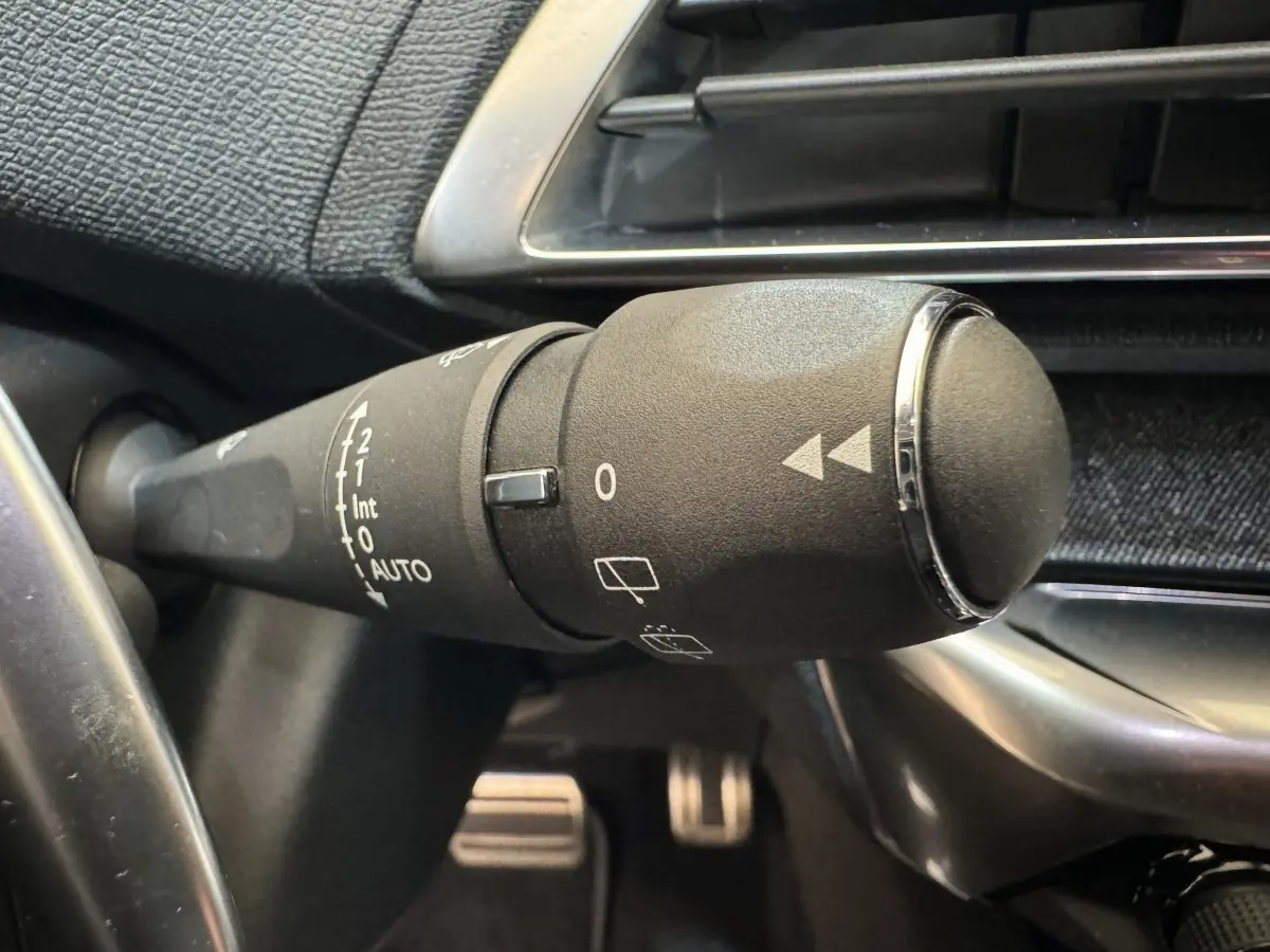Gros plan sur la manette d'essuie-glace noire côté gauche du tableau de bord du Peugeot 3008 blanc de 2019.