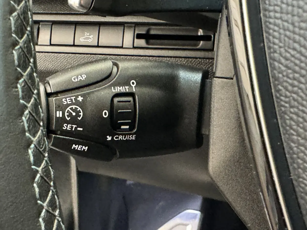 Gros plan sur la commande de régulateur de vitesse à gauche du volant du Peugeot 3008 blanc, version Crossway.