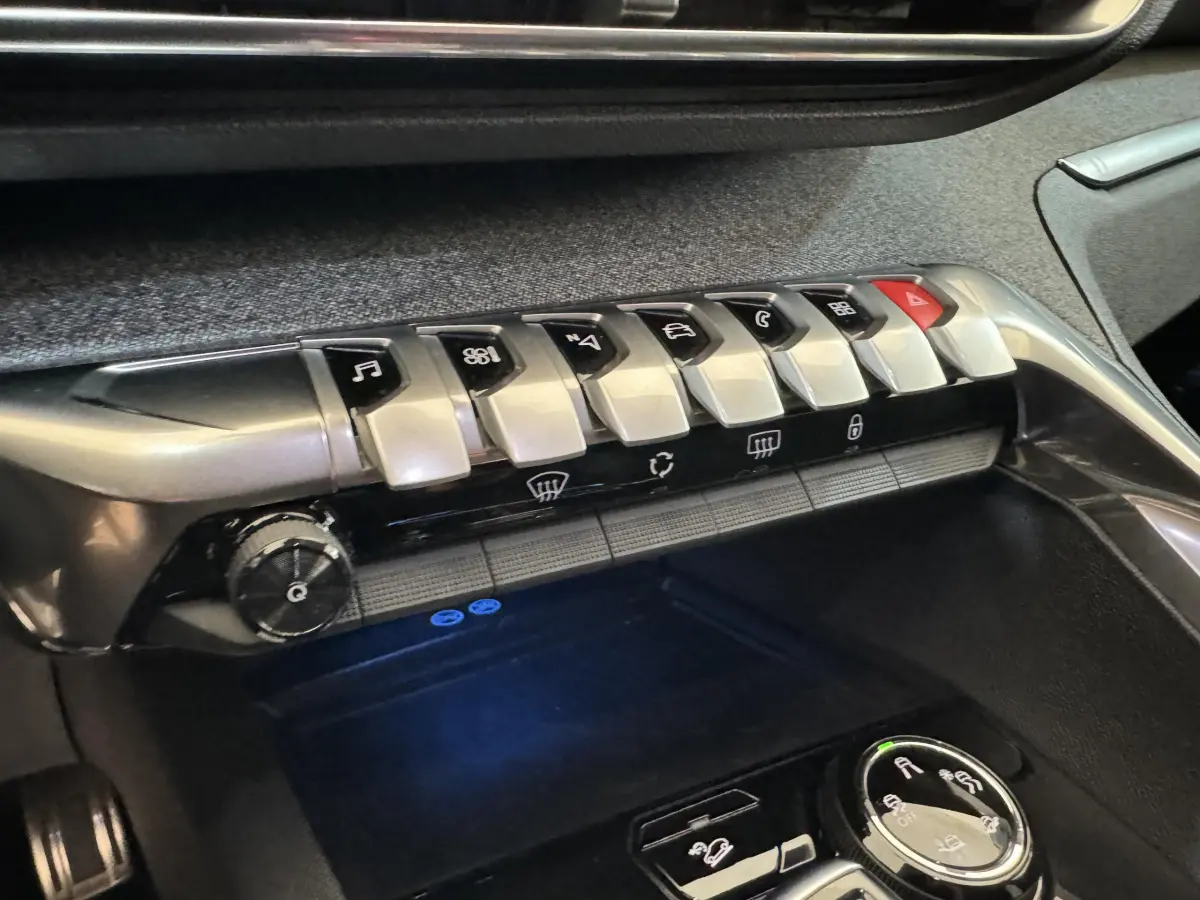 Gros plan sur la console centrale du Peugeot 3008 blanc 2019, montrant les commandes tactiles et boutons argentés du tableau de bord.