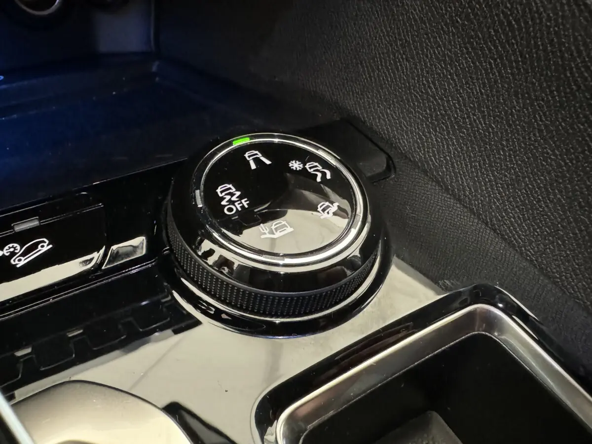 Gros plan sur la molette de sélection des modes de conduite dans l'habitacle du Peugeot 3008 blanc.