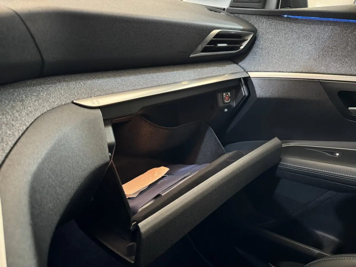 Vue intérieure côté passager du Peugeot 3008 blanc 2019, boîte auto, montrant la boîte à gants ouverte avec documents.
