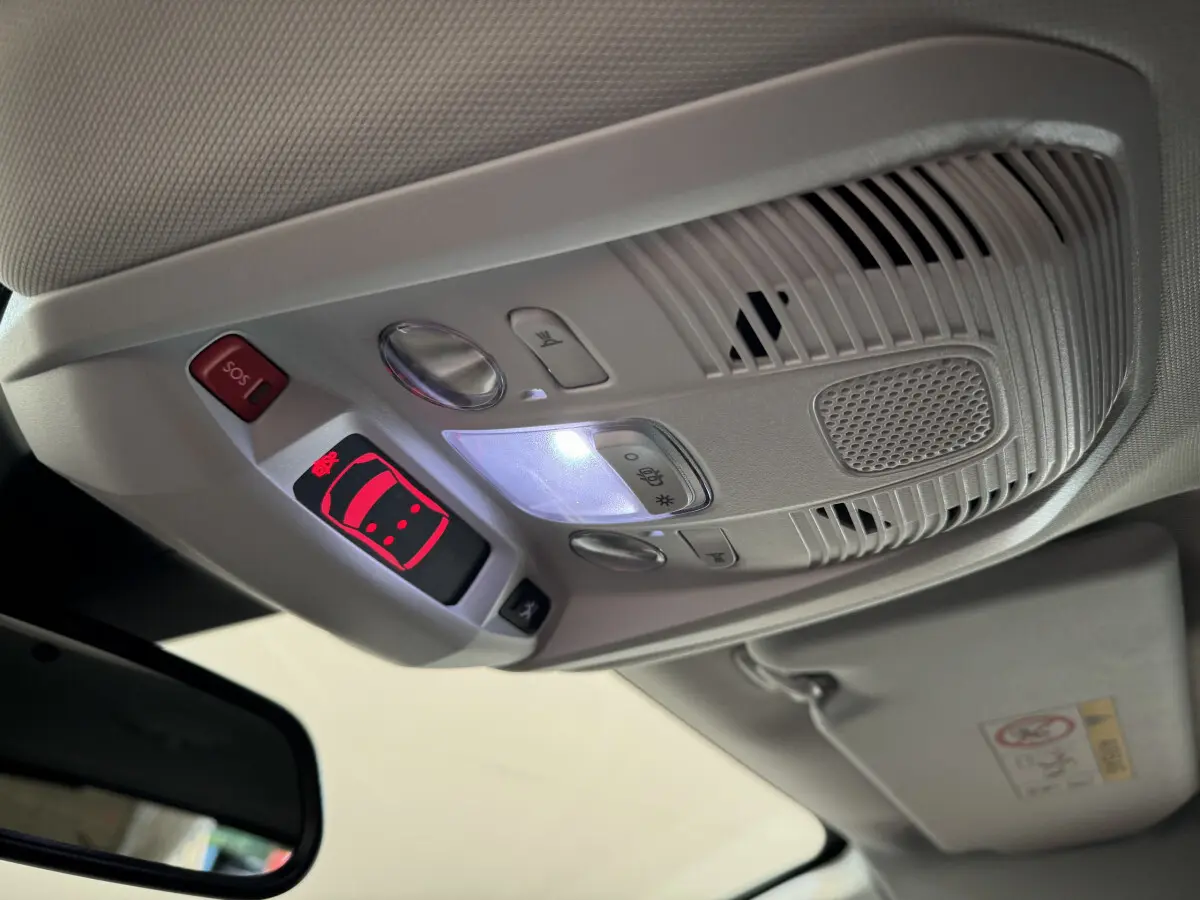 Vue intérieure en gros plan du plafonnier gris avec commandes lumineuses et bouton SOS du Peugeot 3008 blanc 2019.